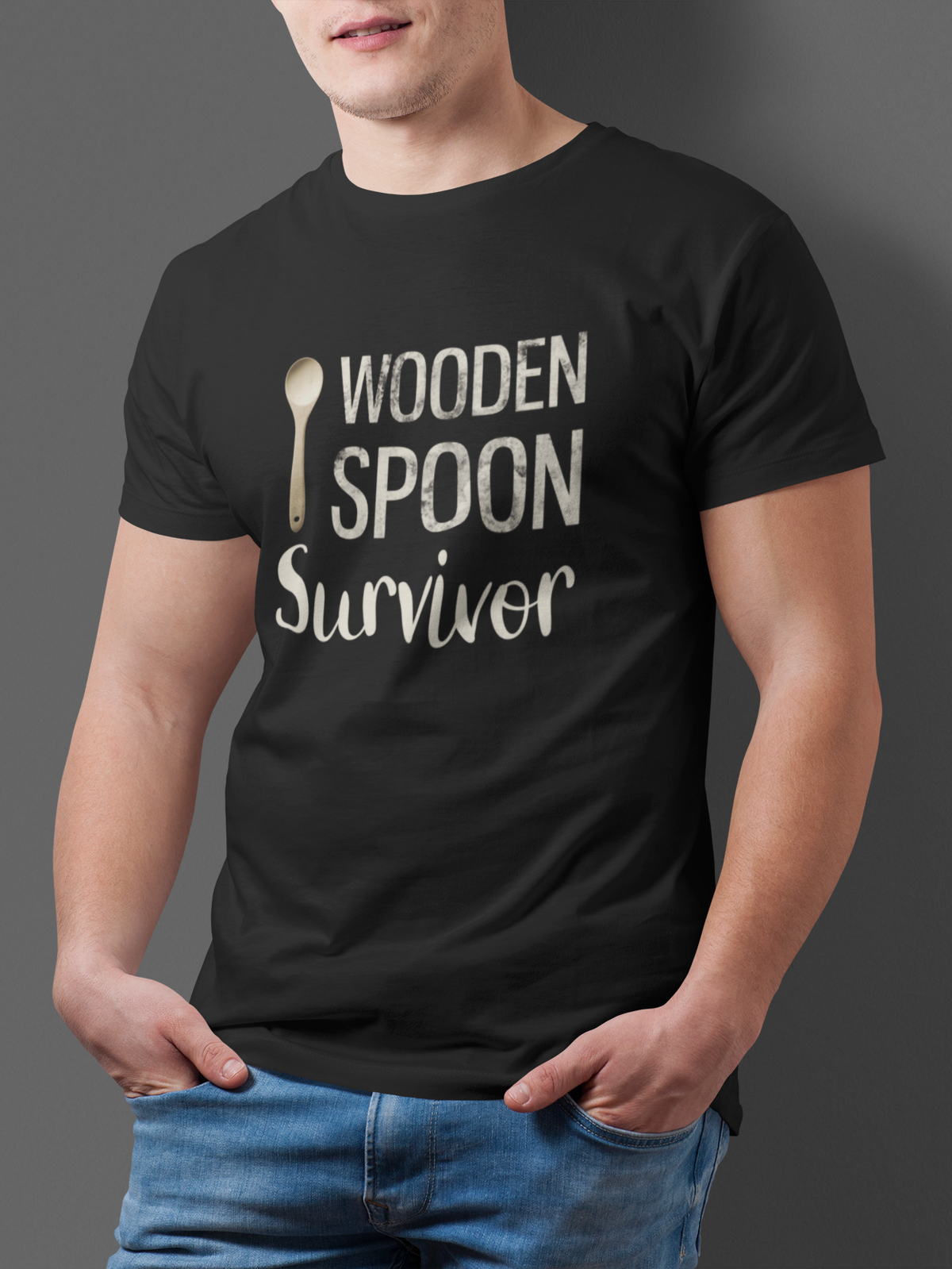 Junger Mann trägt Schwarzes T-Shirt mit Aufdruck Wooden Spoon Survivor und Kochlöffel. Oberkörperansicht