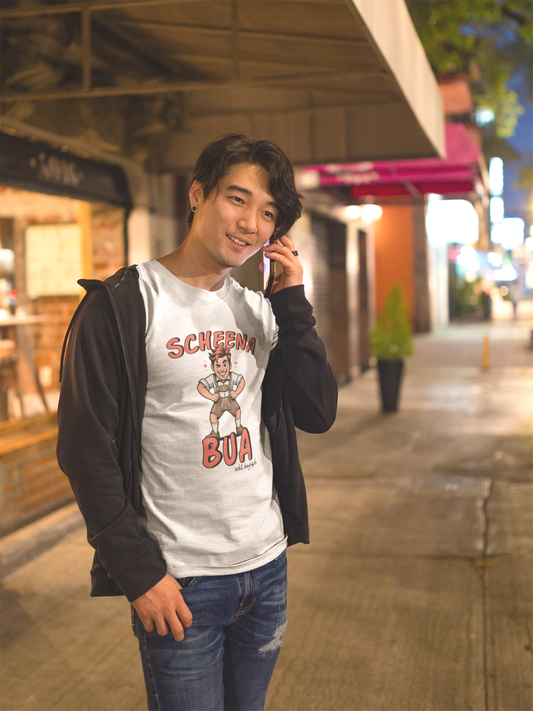 Oberkörperansicht einen jungen Mannes. Er trägt ein weißes T-Shirt mit weißem bayerischen Schriftzug „Scheena Bua“ und bayrischer Comic-Figur