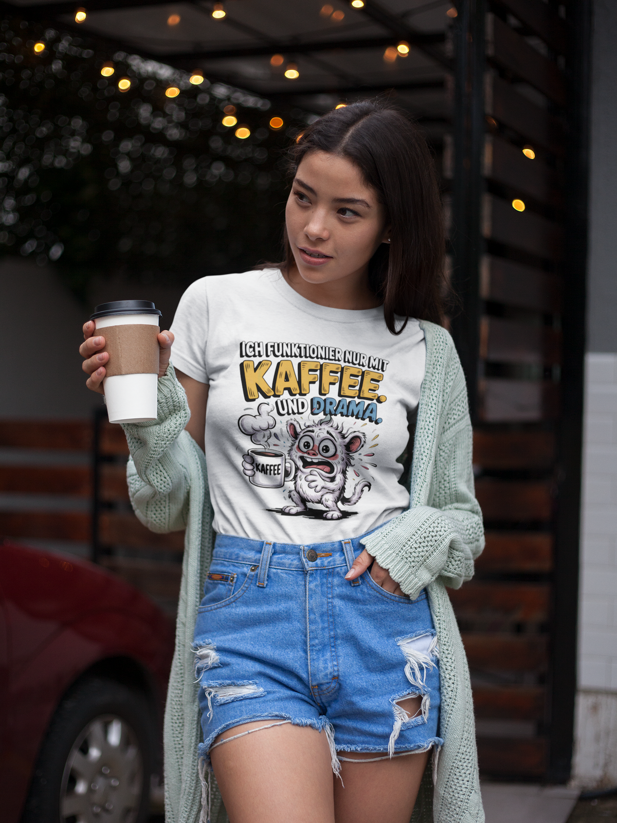 Junge Frau trägt weißes T-Shirt mit crazy Monster und Kaffeebecher (Oberkörperaufnahme)