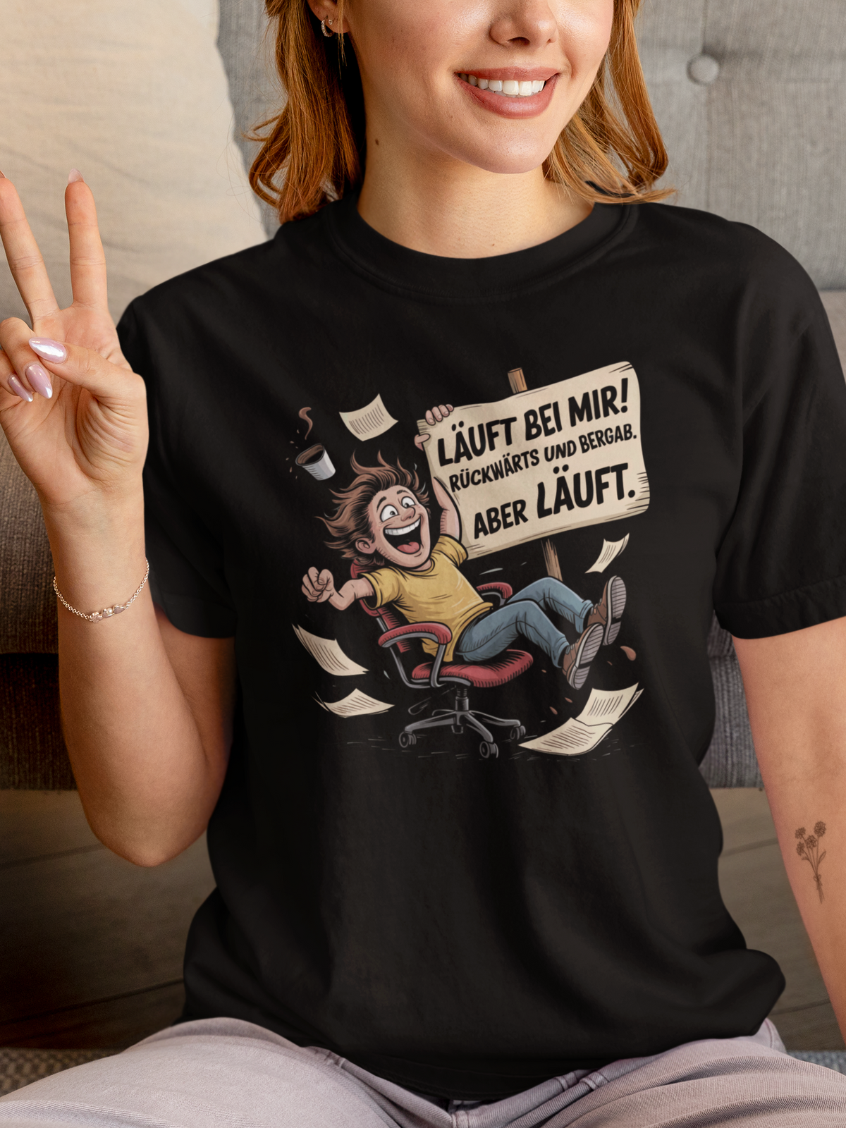 Frau trägt schwarzes T-Shirt mit Büro-Motiv und Spruch (Oberkörperaufnahme)