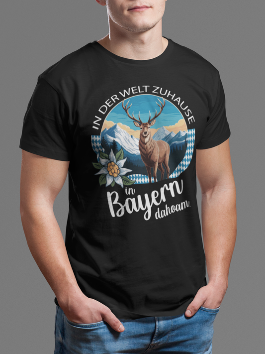 Mann trägt schwarzes T-Shirt mit Motiv „In der Welt zuhause. In Bayern dahoam“ (Oberkörper)