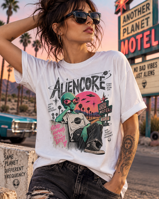 Weibliches Model trägt weißes Aliencore T-Shirt mit Alien-Motel-Motiv vor einem Retro-Motel