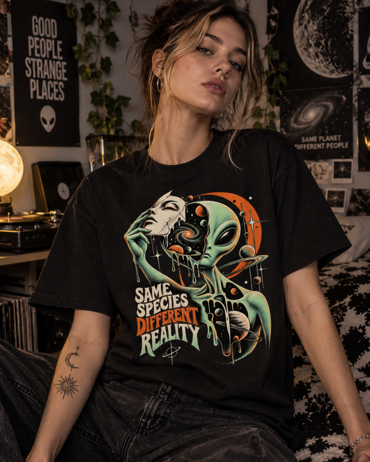 Weibliches Model trägt schwarzes T-Shirt mit Alien mit menschlicher Maske und Planeten mit Same Species Different Reality