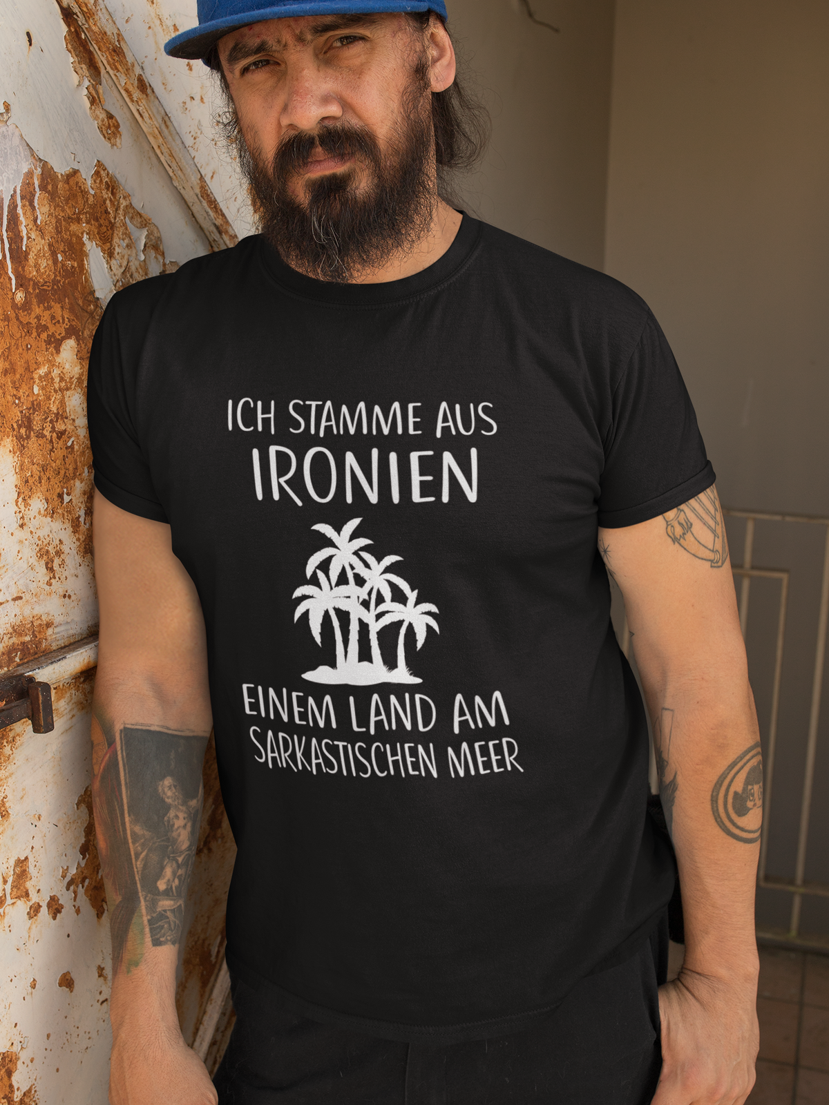 Mann trägt schwarzes Shirt mit ironischem Spruch „Ich stamme aus Ironien…“ (Oberkörper)