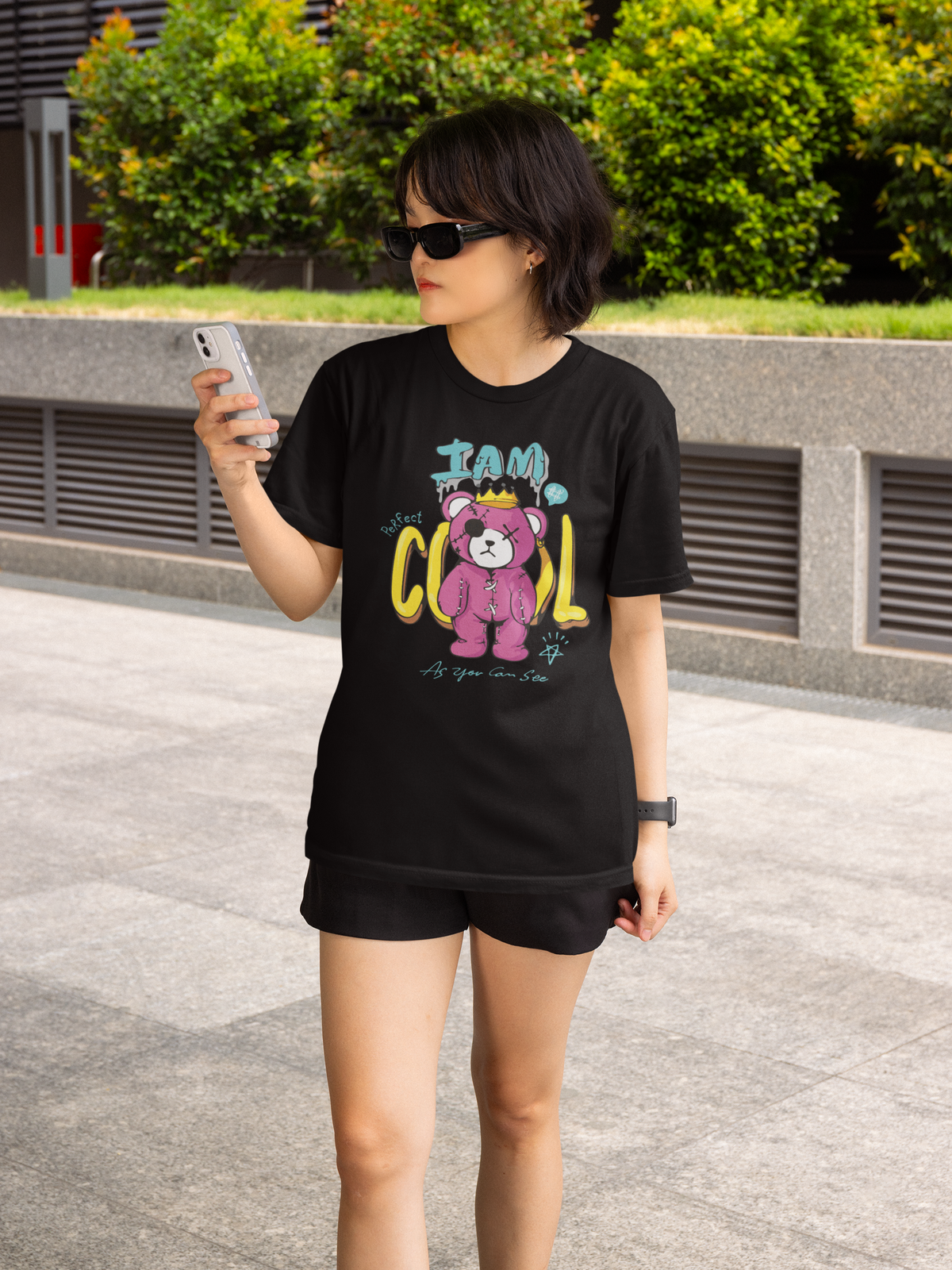 Junge Frau trägt schwarzes T-Shirt mit Teddy-Motiv (Oberkörperaufnahme)