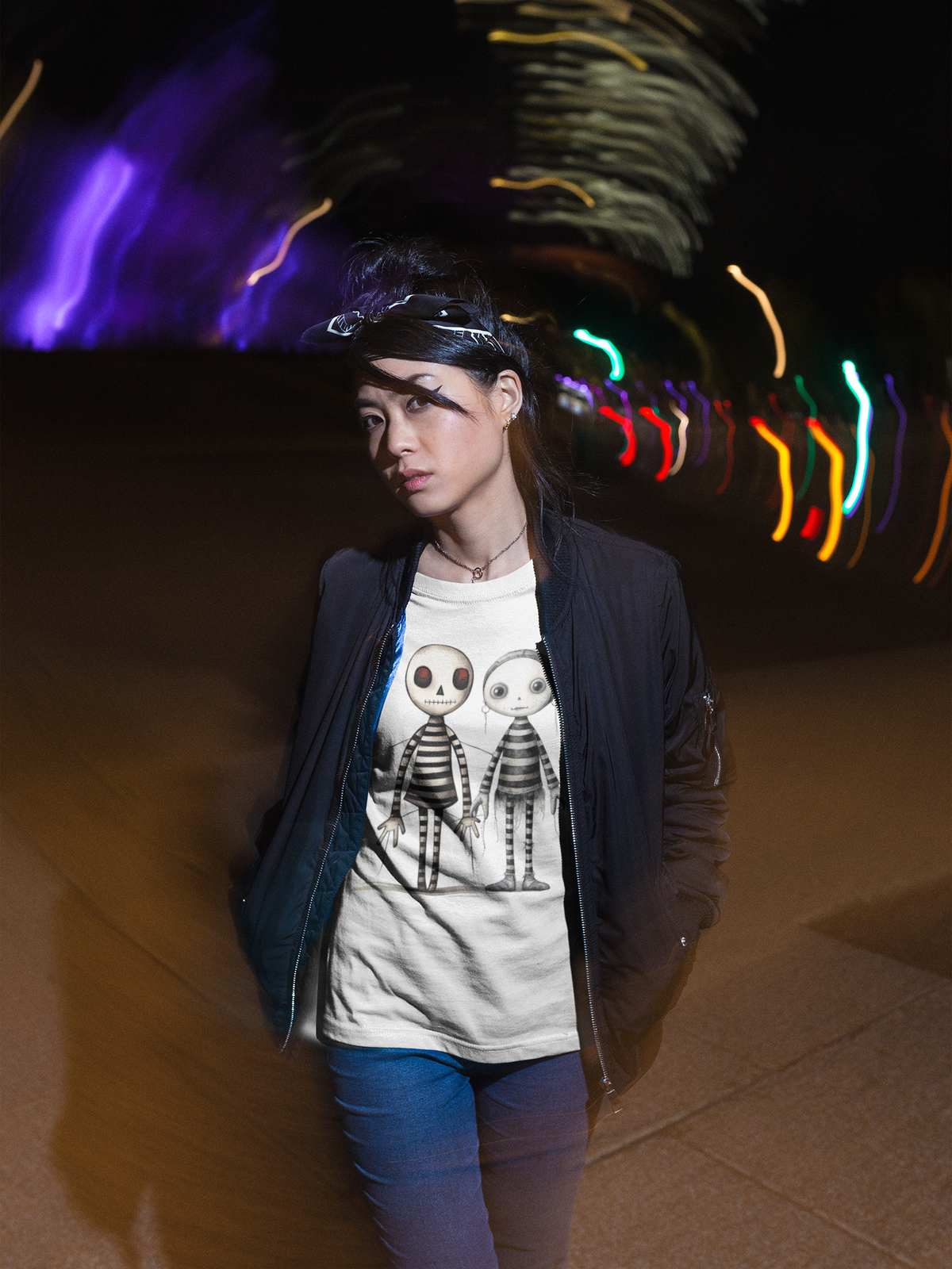 Junge Frau, mit offener schwarzer Jacke, trägt ein weißes T-Shirt mit zwei gezeichneten Voodoo Dolls in Strichzeichnung, Oberkörperansicht