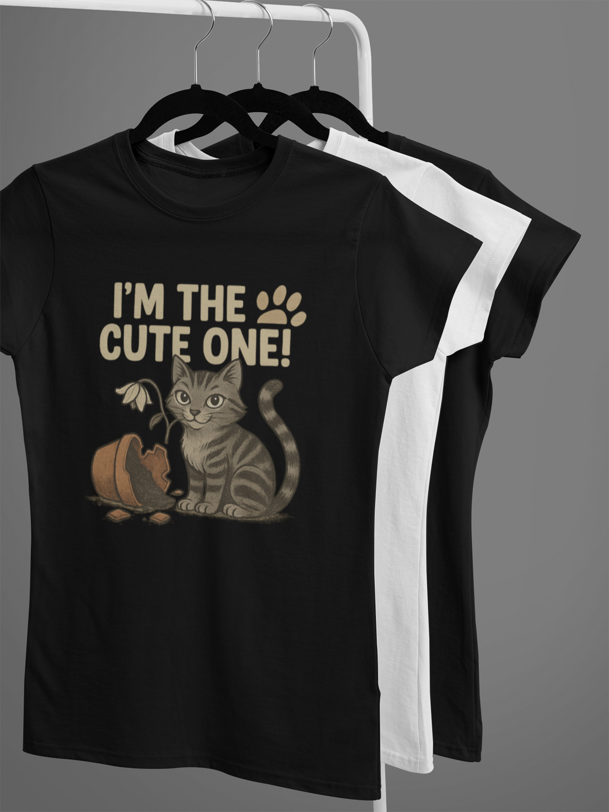 T-Shirts auf Kleiderständer. Das vorder ist schwarz mit Katzen-Motiv und Aufschrift: I´m the cute one!