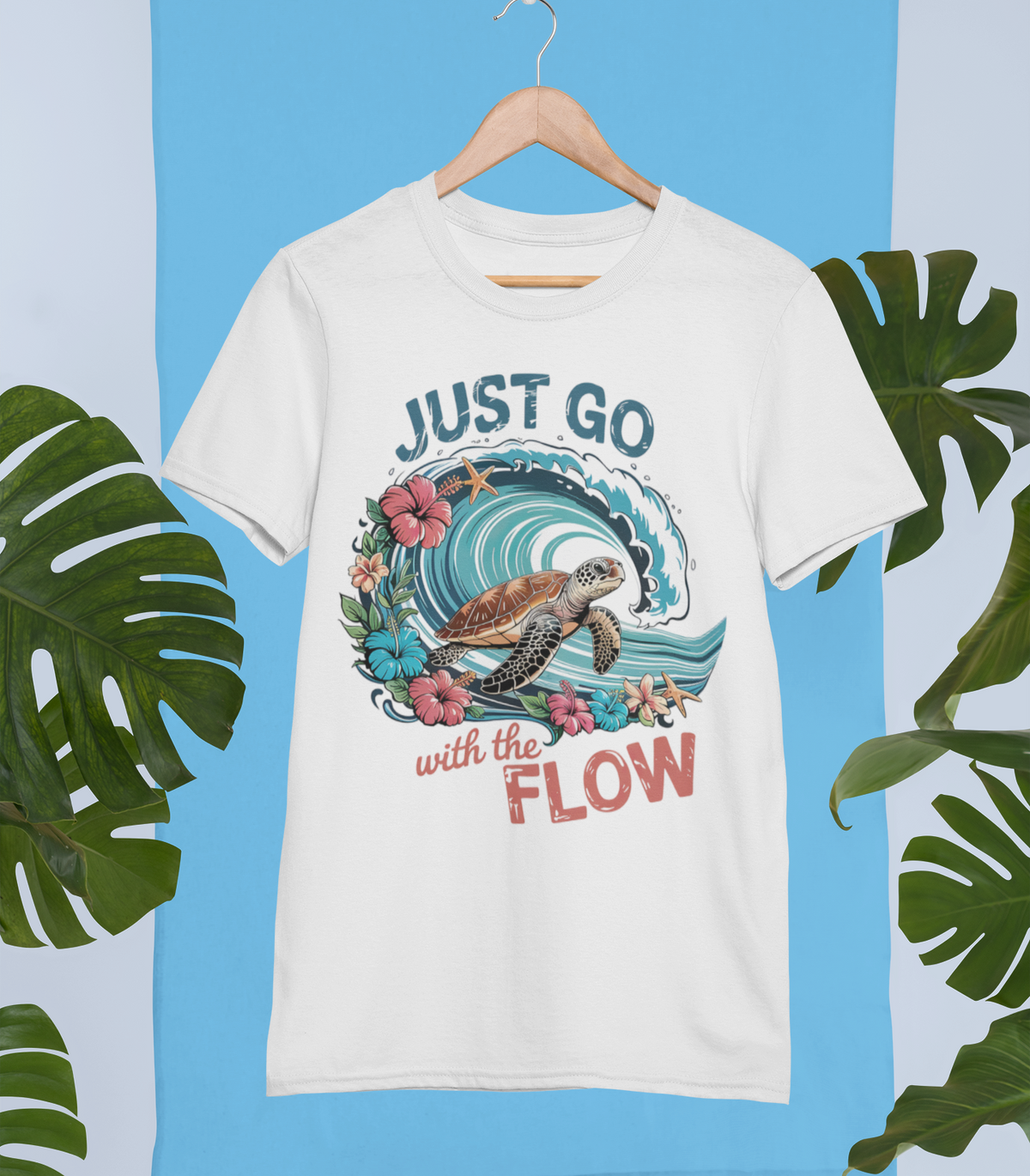 Weißes T-Shirt mit Meereswelle, Hibiskusblüten, relaxter Schildkröte und dem Spruch „Just go with the flow“ im Retro-Stil. Links und rechts im Bild tropische Blätter.