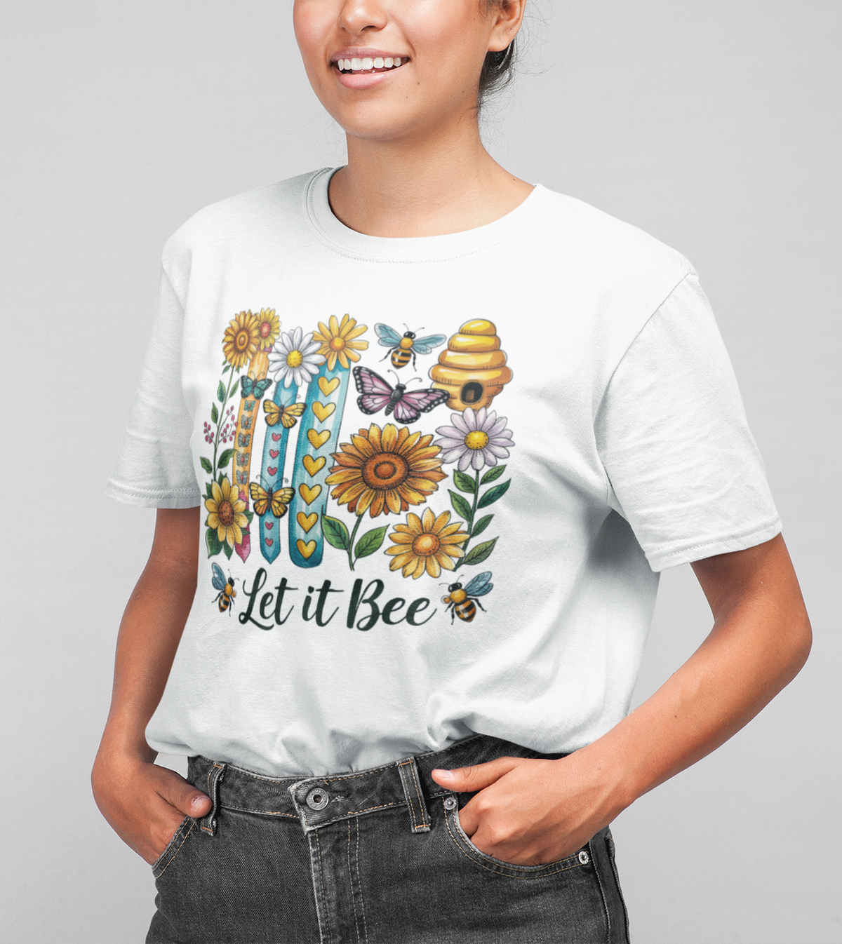 Frau trägt ein weißes T-Shirt mit Bienen, Blumen, Schmetterlingen und dem Schriftzug „Let it bee“ – sommerlich, natürlich und freundlich