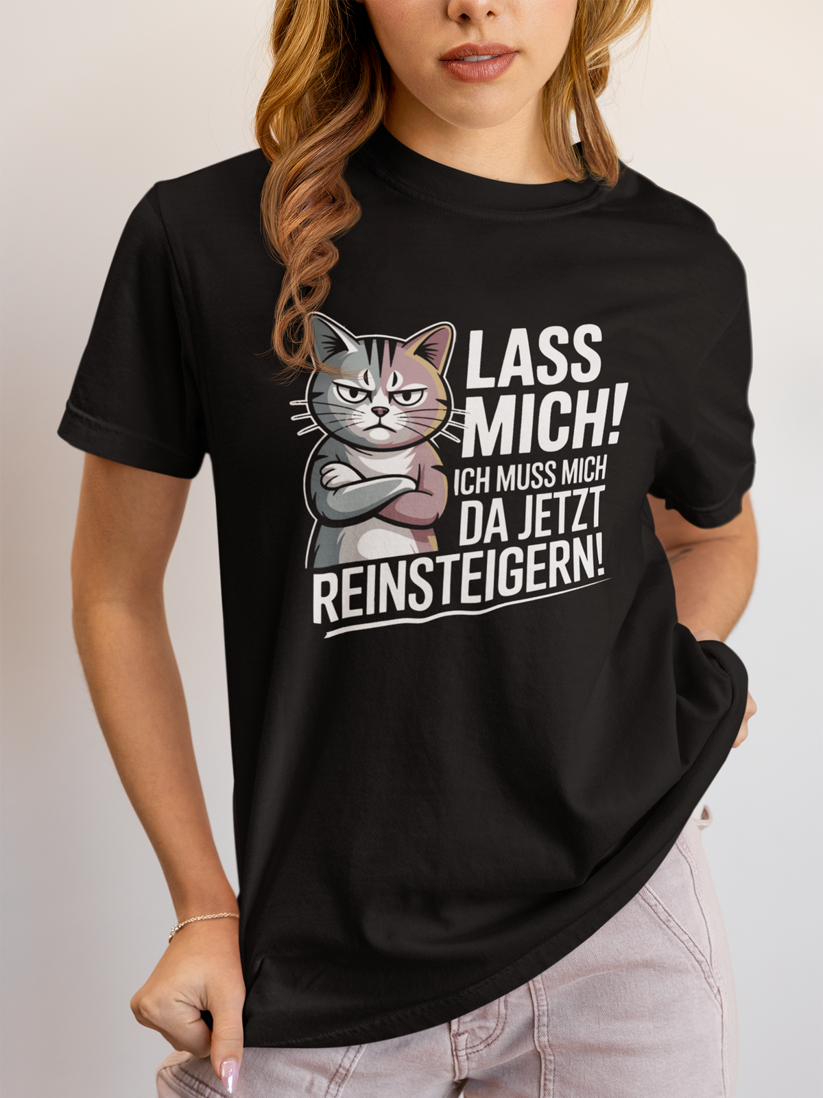 Frau trägt ein schwarzes T-Shirt mit Katzenmotiv und der Aufschrift "Lass mich! Ich muss mich da jetzt reinsteigern!"