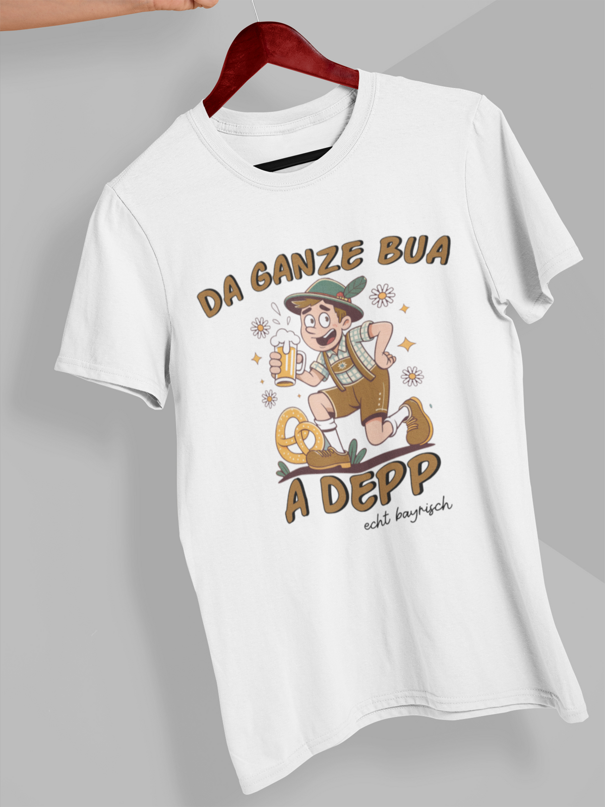 Weißes T-Shirt mit Motiv: bayerischer Mann mit Maßkrug und Spruch „Da ganze Bua a Depp“, auf Kleiderbügel hängend.