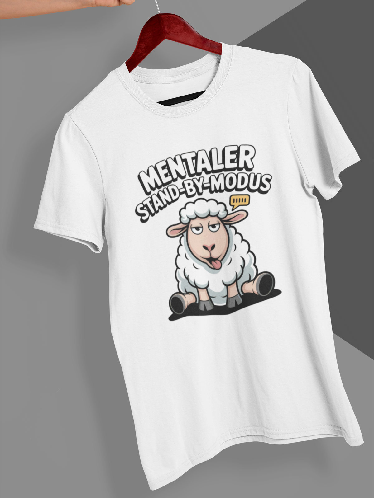 Weißes T-Shirt mit Schaf-Motiv und Spruch auf Kleiderbügel 