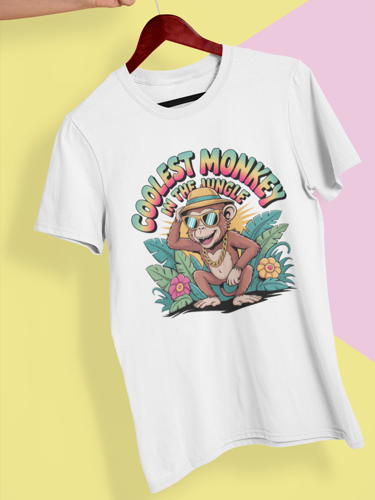Weißes T-Shirt mit tropischem Affenmotiv und Spruch „Coolest Monkey in the Jungle“, hängend an Kleiderbügel