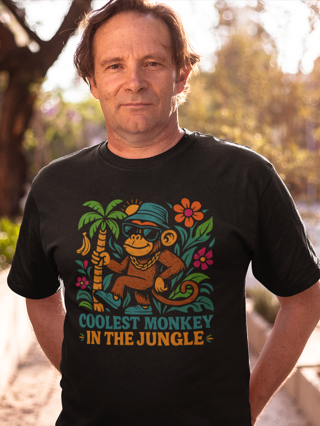 Mann trägt schwarzes Shirt mit Vintage-Dschungelmotiv (Oberkörperaufnahme)