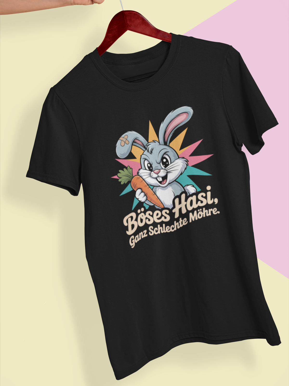 Schwarzes T-Shirt mit bösem Hasen und dem Spruch „Böses Hasi. Ganz schlechte Möhre“, auf Kleiderbügel.