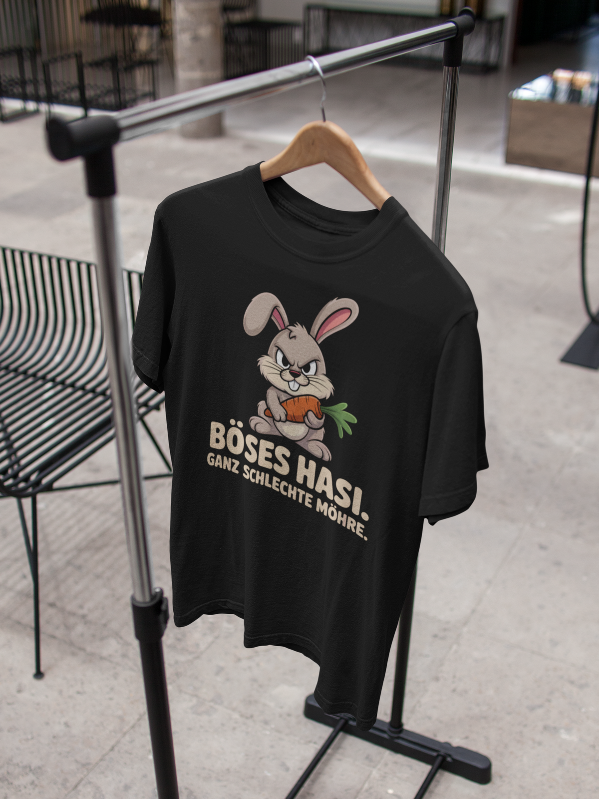 Schwarzes T-Shirt mit bösem Hase und Spruch „Böses Hasi. Ganz schlechte Möhre“, hängend auf Kleiderständer
