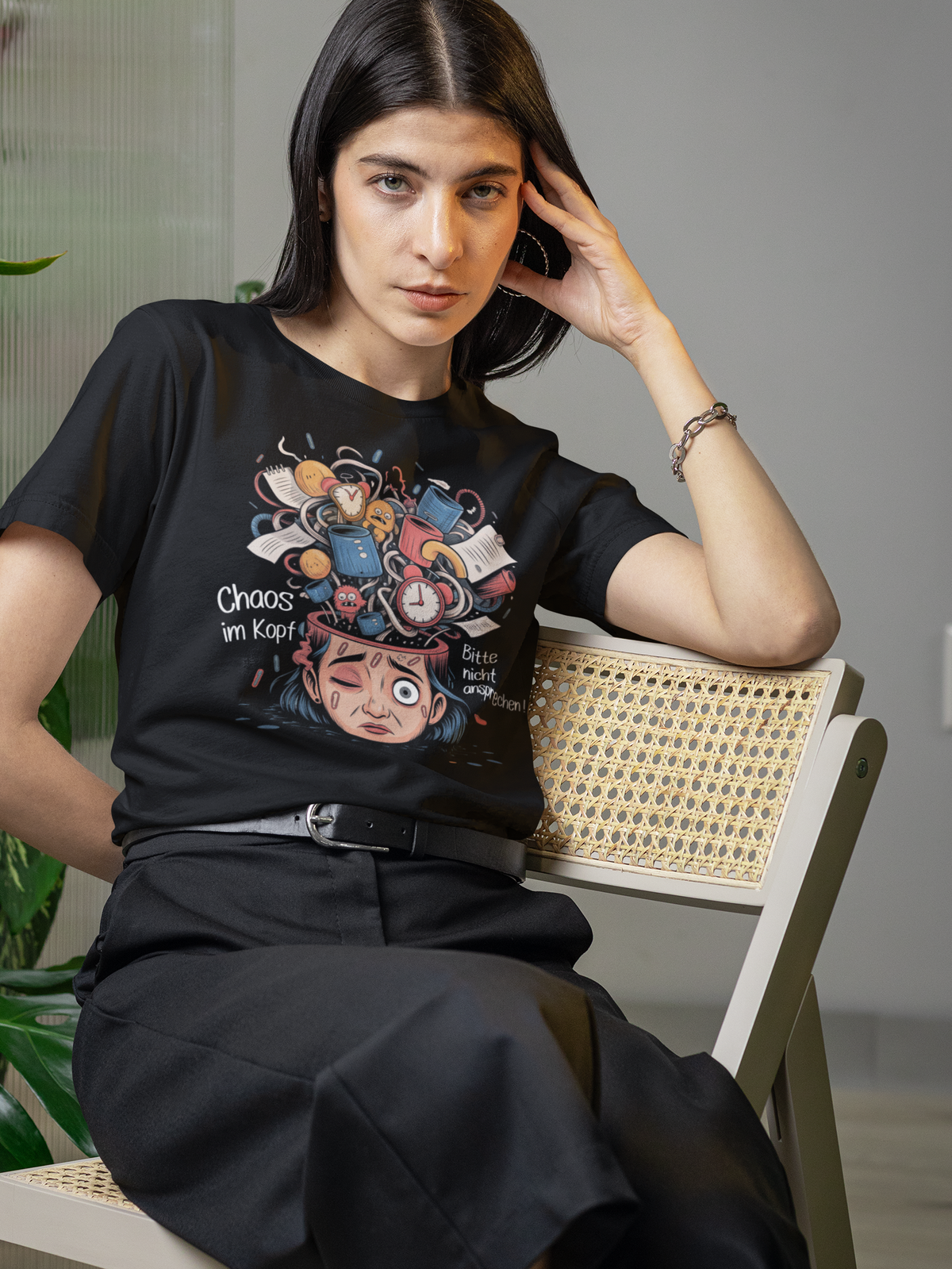 Frau trägt schwarzes Shirt mit Kopf-Chaos-Motiv und dem Spruch „Chaos im Kopf – Bitte nicht ansprechen“ (Oberkörperaufnahme)