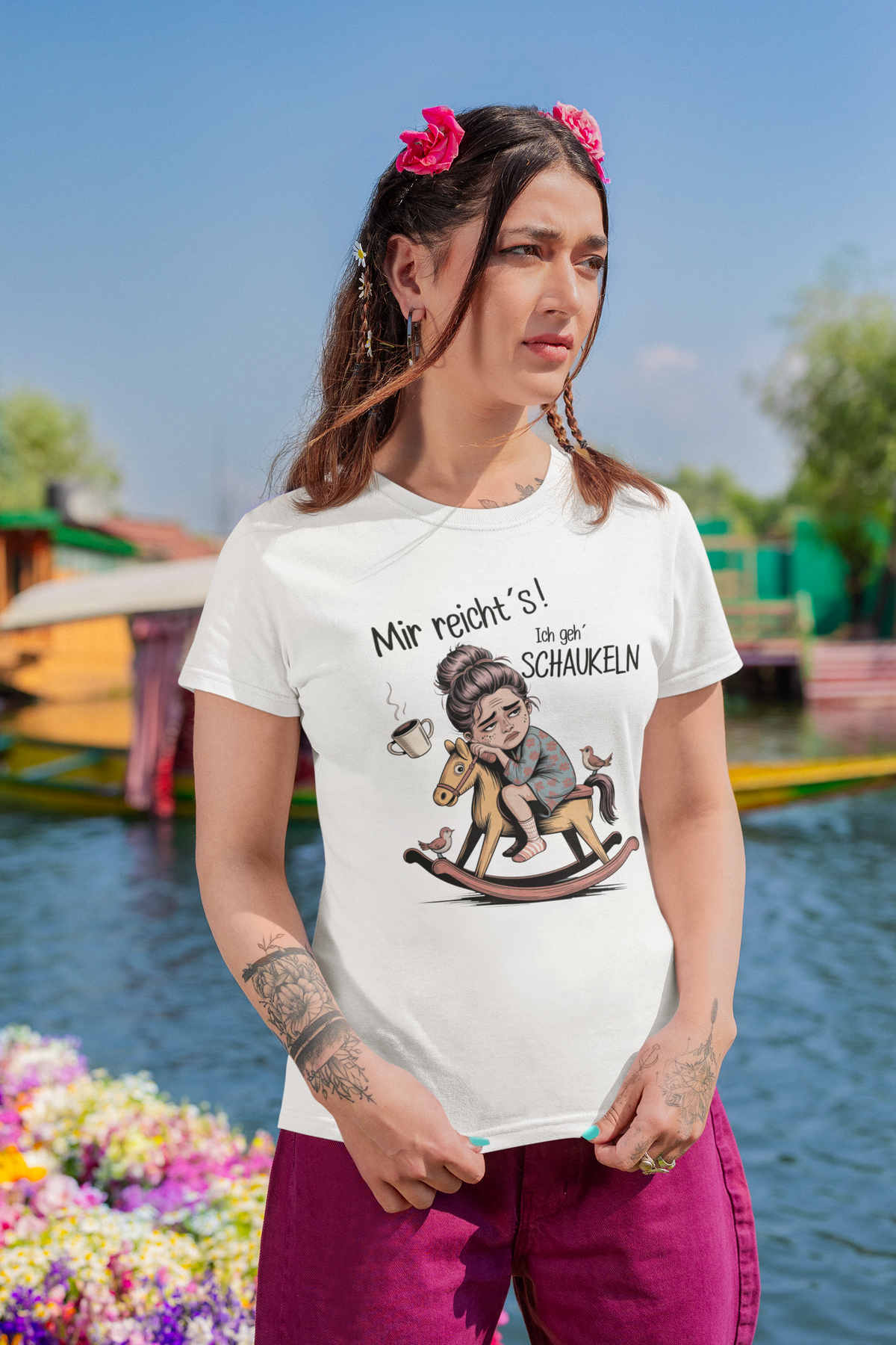 Frau trägt weißes T-Shirt mit dem Text „Mir reichts – Ich geh schaukeln“ und einem Schaukelpferd-Motiv (Oberkörperaufnahme)