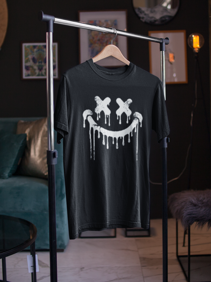 Schwarzes T-Shirt mit Smilie-Gesicht im Graffiti-Look, hängt an Kleiderständer.