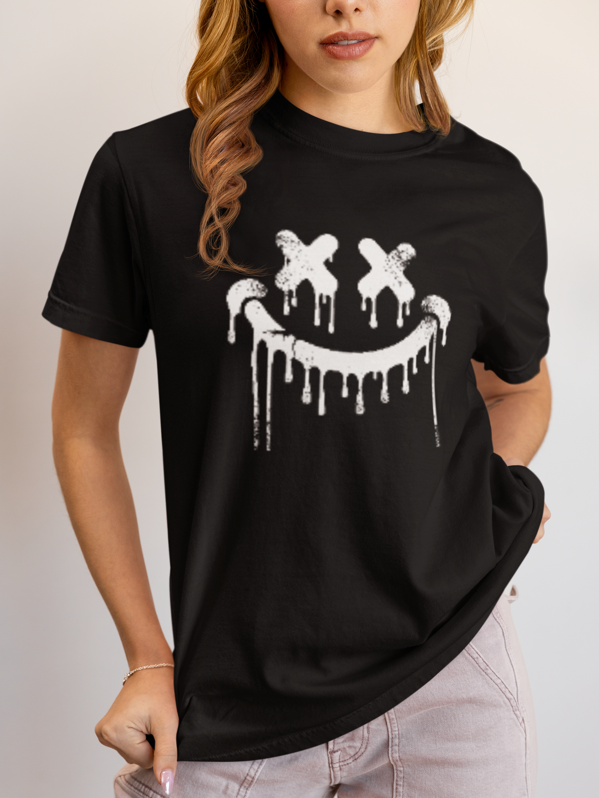Junge Frau trägt ein schwarzes T-Shirt mit Smilie-Gesicht im Graffiti-Look. Oberkörperansicht.