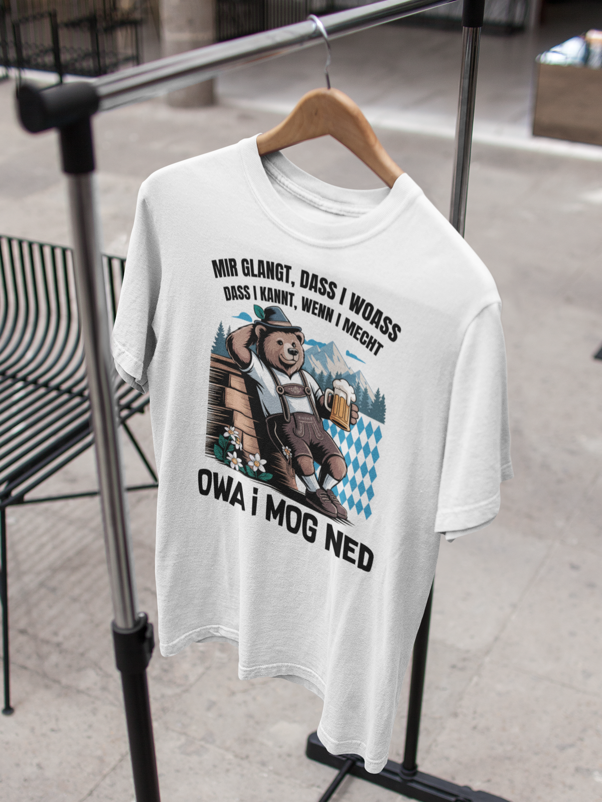 Weißes T-Shirt mit Bär und bayerischem Spruch auf Kleiderbügel an Ständer