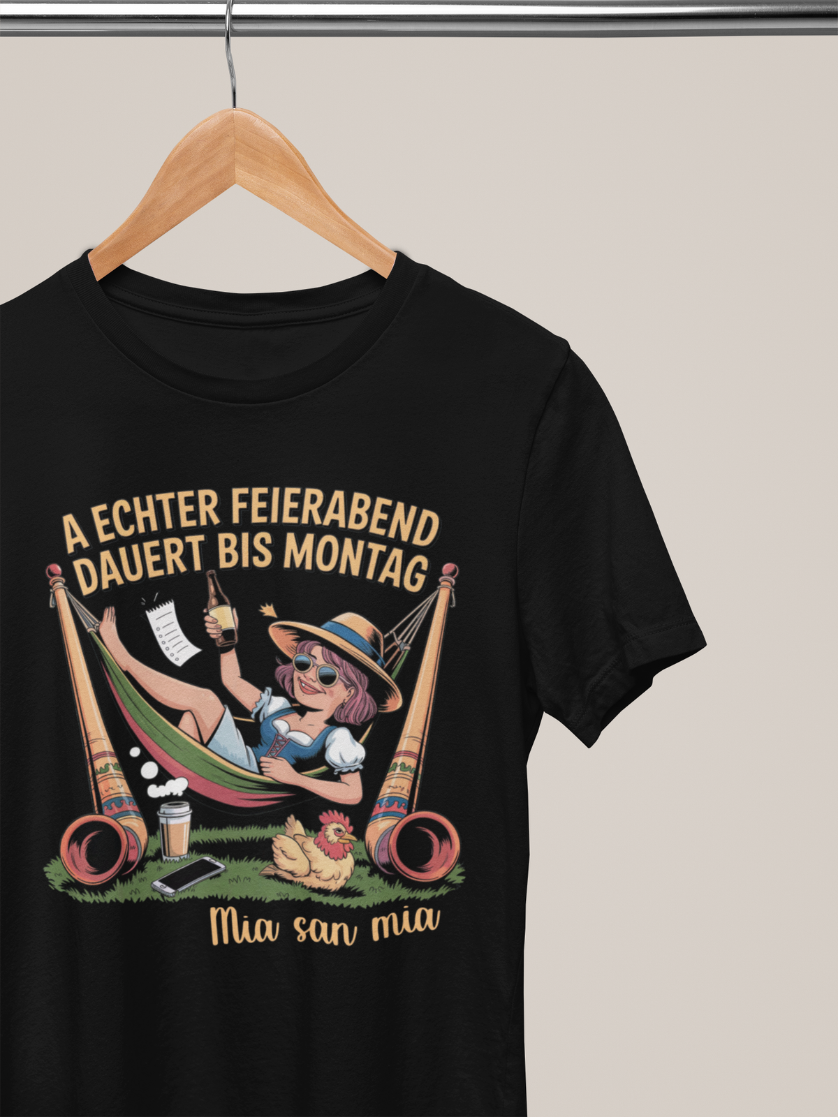 chwarzes T-Shirt mit Madl-Motiv in Hängematte und Spruch auf Kleiderbügel 