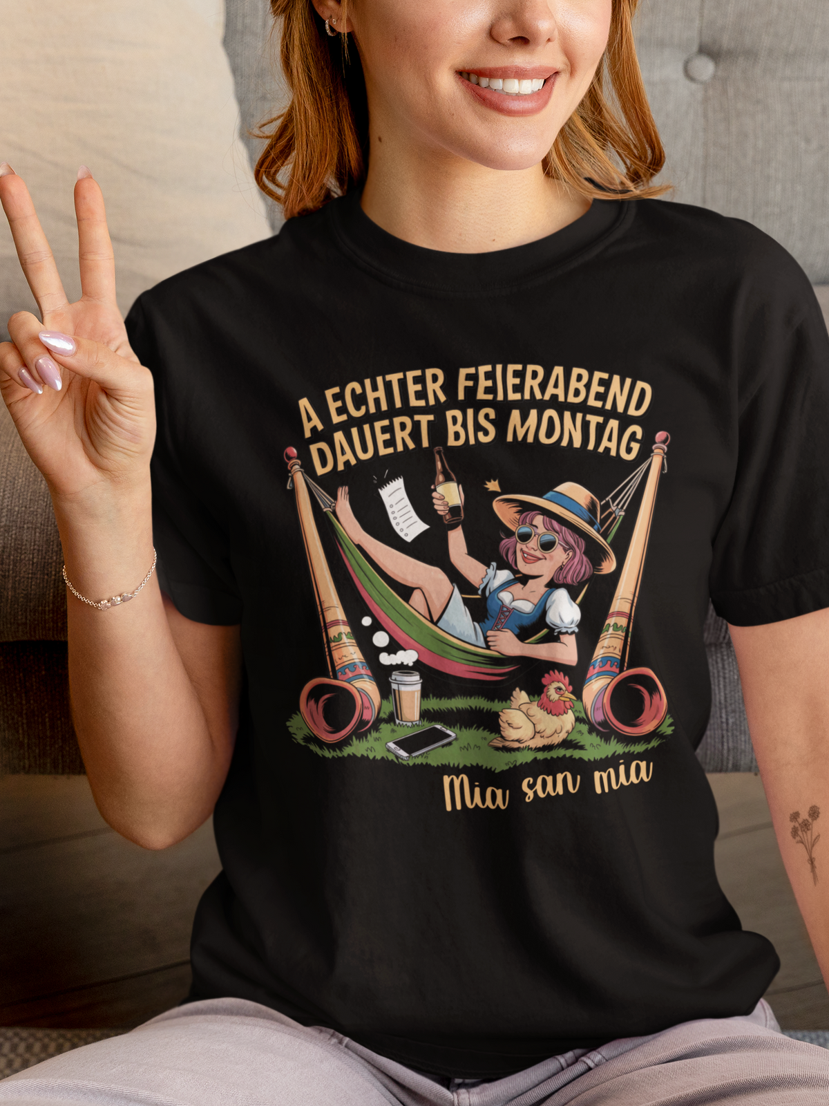 Frau trägt schwarzes T-Shirt mit Motiv „Feierabend bis Montag“ und Madl in Hängematte (Oberkörper)