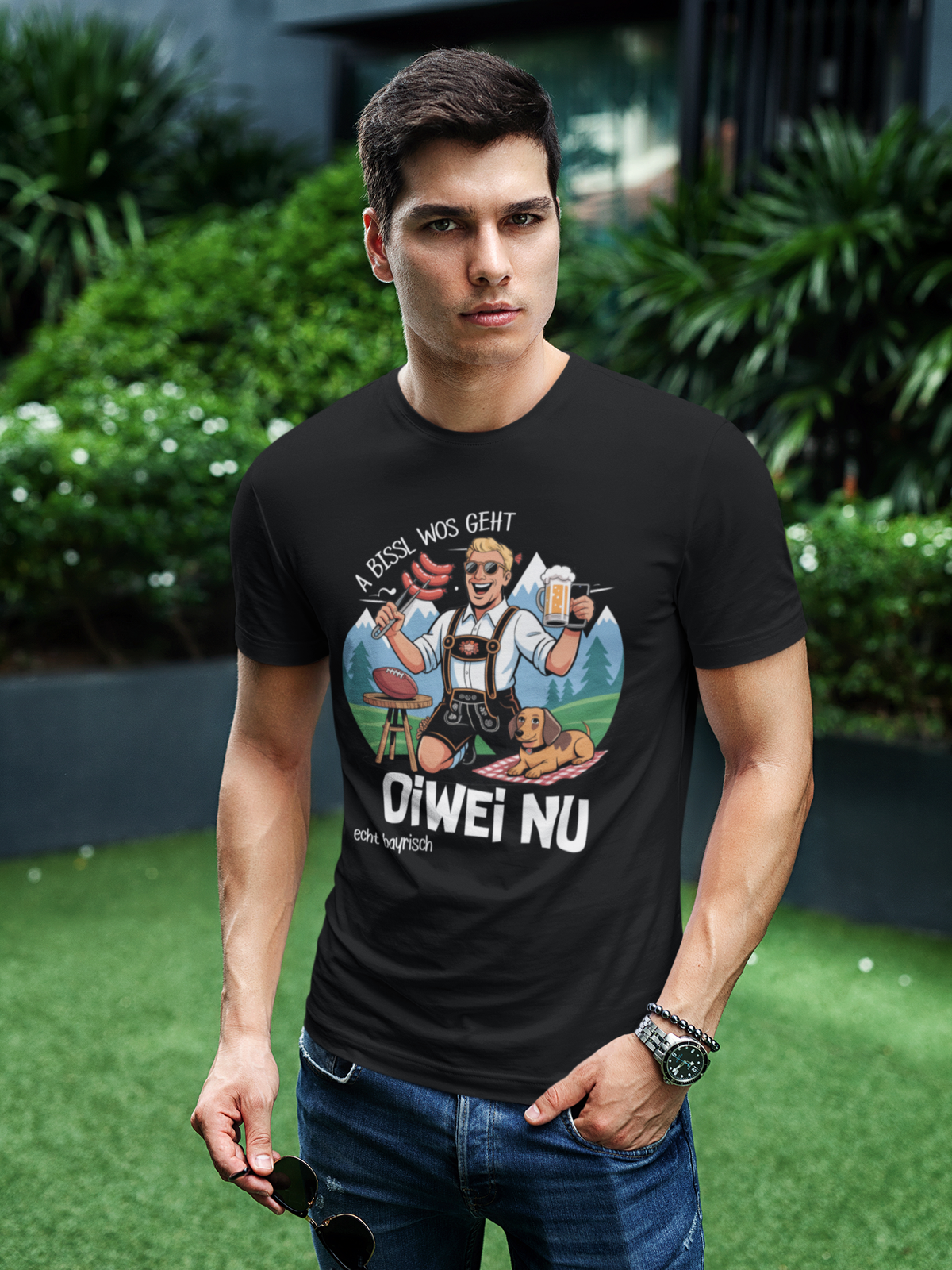 Mann trägt schwarzes T-Shirt mit Spruch „A bissl wos geht oiwei nu“ (Oberkörper)