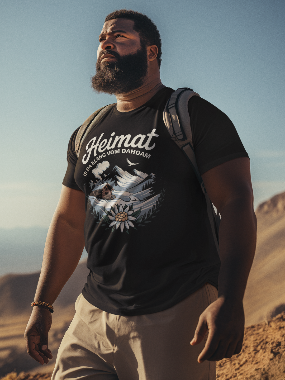 Mann trägt schwarzes T-Shirt mit Motiv „Heimat is da Klang vom Dahoam“ (Oberkörper)