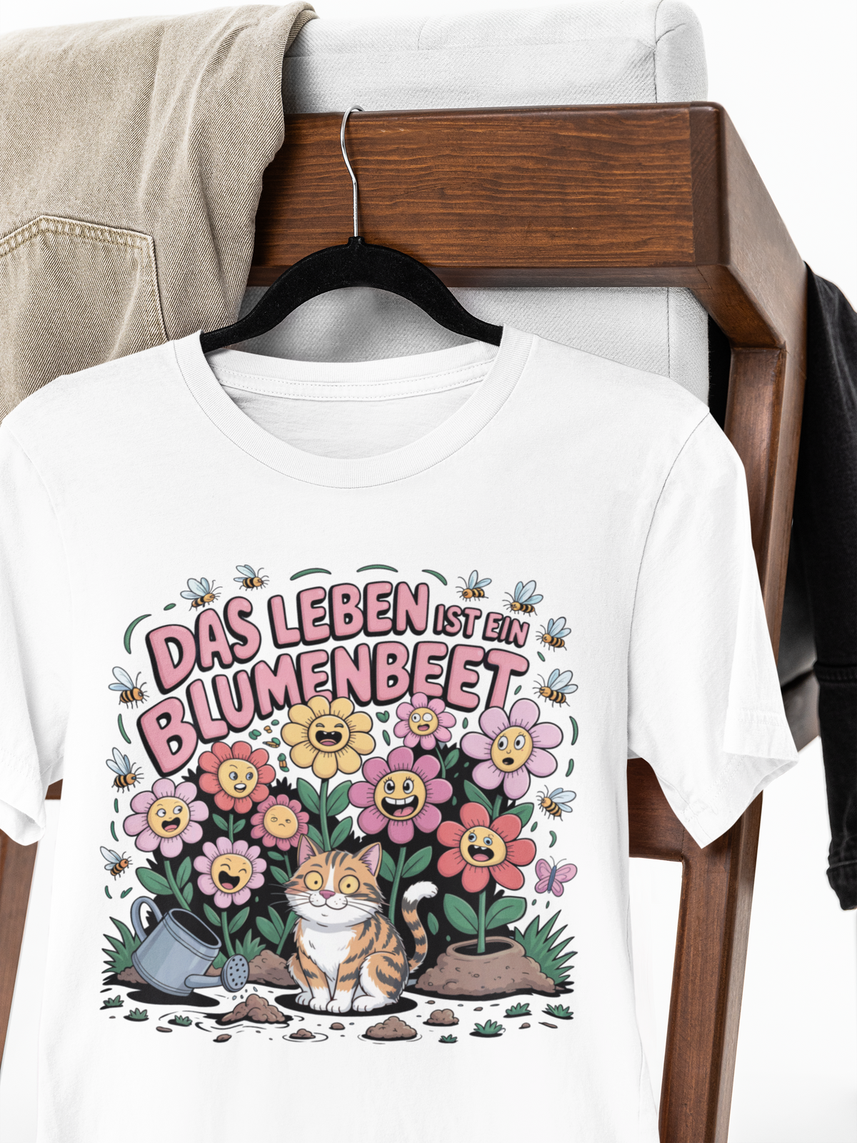 Weißes T-Shirt mit Motiv „Das Leben ist ein Blumenbeet“ auf Kleiderbügel 

