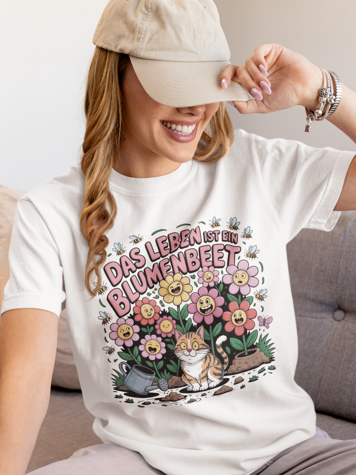 Frau trägt weißes T-Shirt mit Motiv „Das Leben ist ein Blumenbeet“ und Katze (Oberkörper)

