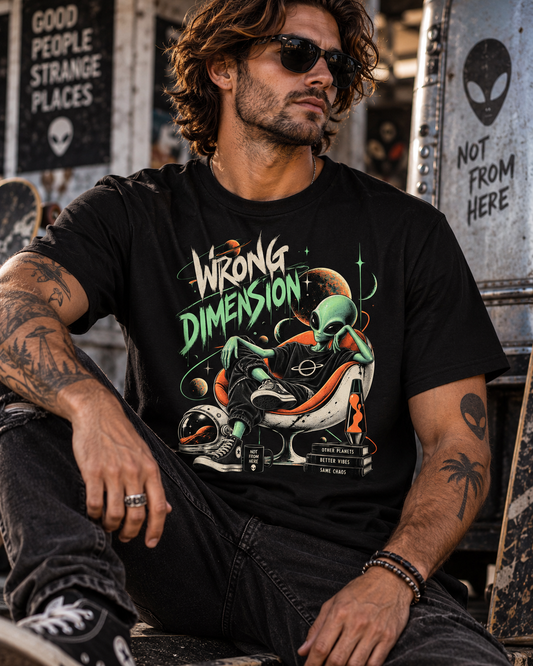 Männliches Model trägt schwarzes T-Shirt mit Alien im orangefarbenen Sessel mit Planeten und Wrong Dimension