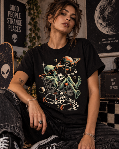 Weibliches Model trägt schwarzes T-Shirt mit Alien im Einkaufswagen mit Planeten und Schachbrettband
