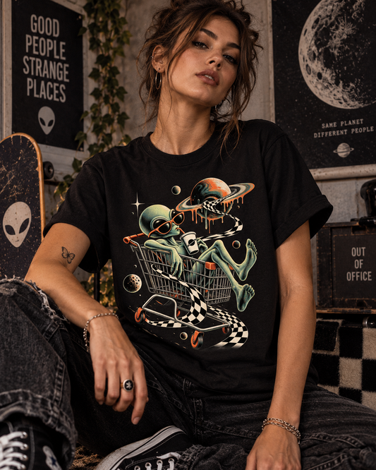 Weibliches Model trägt schwarzes T-Shirt mit Alien im Einkaufswagen mit Planeten und Schachbrettband