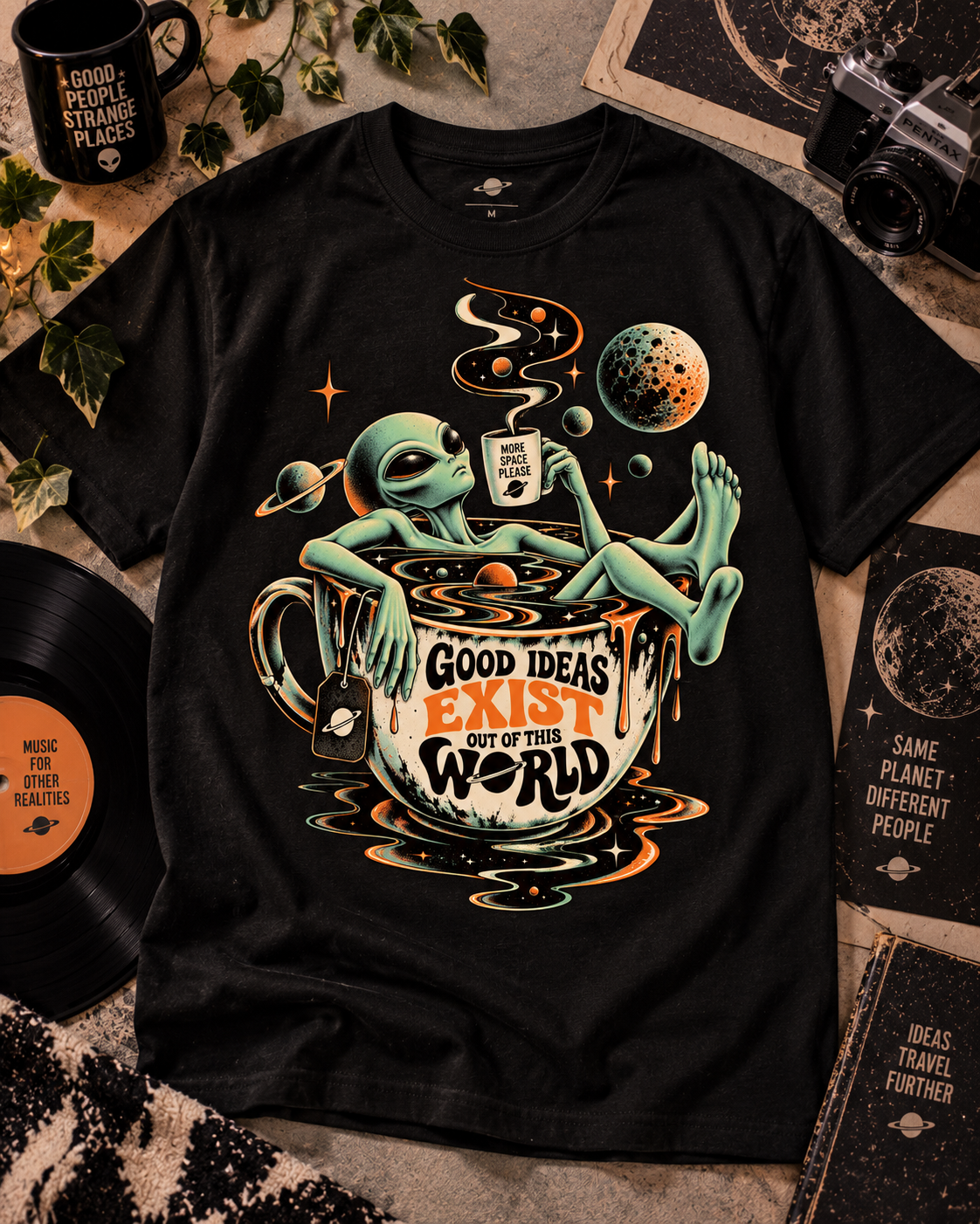 Schwarzes T-Shirt ohne Model mit Alien an einer Kaffeetasse, Dampf und Planeten mit Good Ideas Exist Out of This World