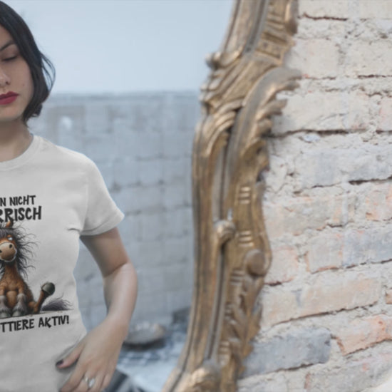 Mödchen vor einem Spiegel,d as sich selbstbewußt durch die Haare streciht. it T-Shirt mit Aufdruck: Ich bin nicht störrisch
