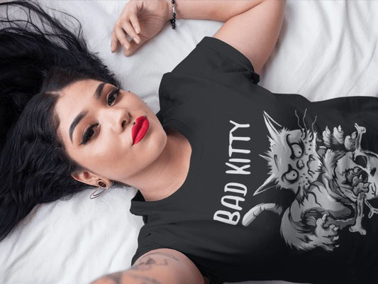 Frau liegend, die ein schwarzes Shirt trägt mit Aufschrift "Bad Kitty"