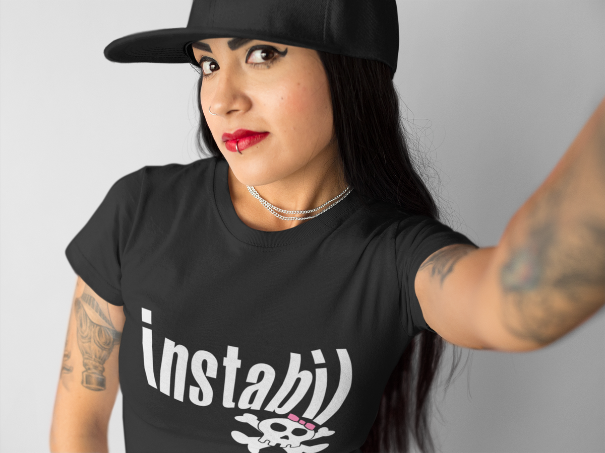 Mädchen mit Lippenpiercing trägt schwarzes Shirt mit weißem Skully-Motiv und frechem Schriftzug „Instabil“.