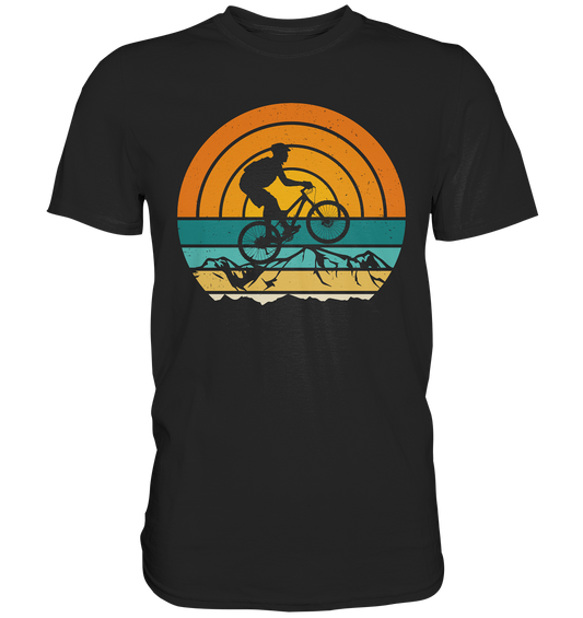 Schwarzes T-Shirt mit Retro-Mountainbike-Print vor Bergkulisse ohne Text