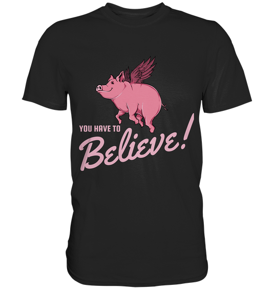 Schwarzes Premium T-Shirt mit rosa Schwein mit Flügeln und dem Spruch „You have to believe!“.