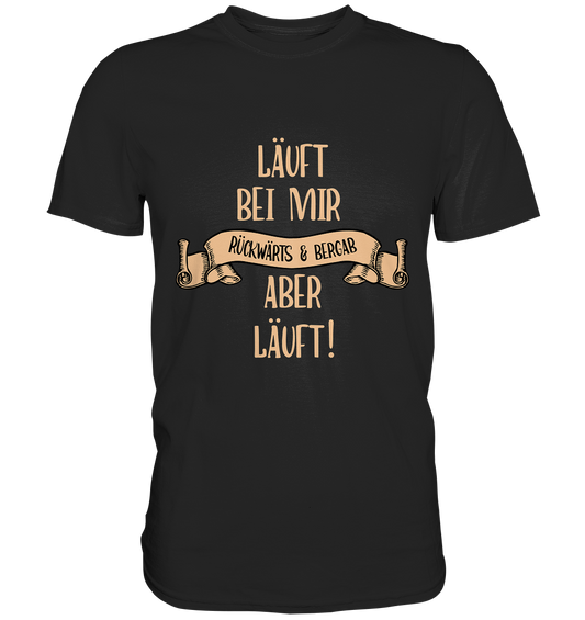 Schwarzes T-Shirt mit dem weißen Text „Läuft bei mir. Rückwärts und bergab. Aber läuft!“